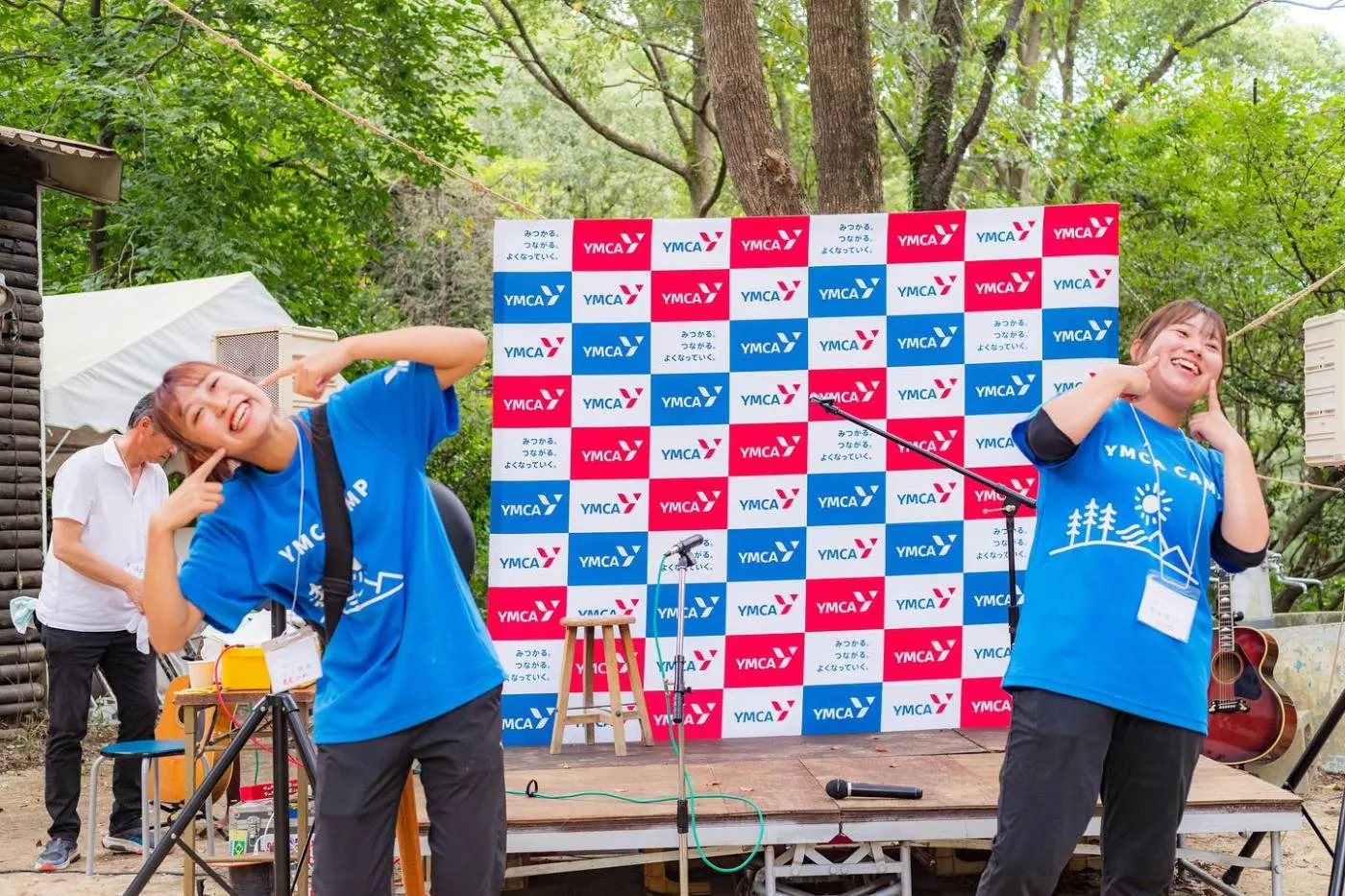 50周年の記念式典。YMCAの幕の前で、司会をするリーダーたち