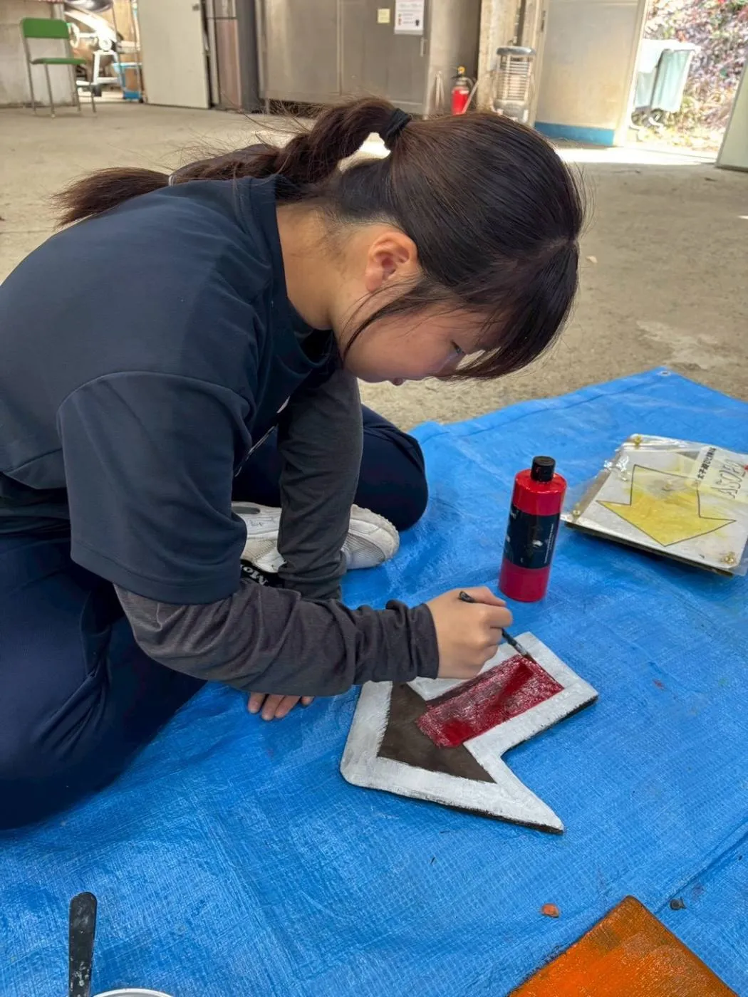 リーダーが看板に色を塗っているところ